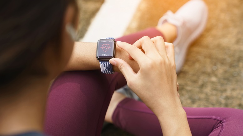 Hand with Apple Watch Series 4 with Heart Rate on the screen.