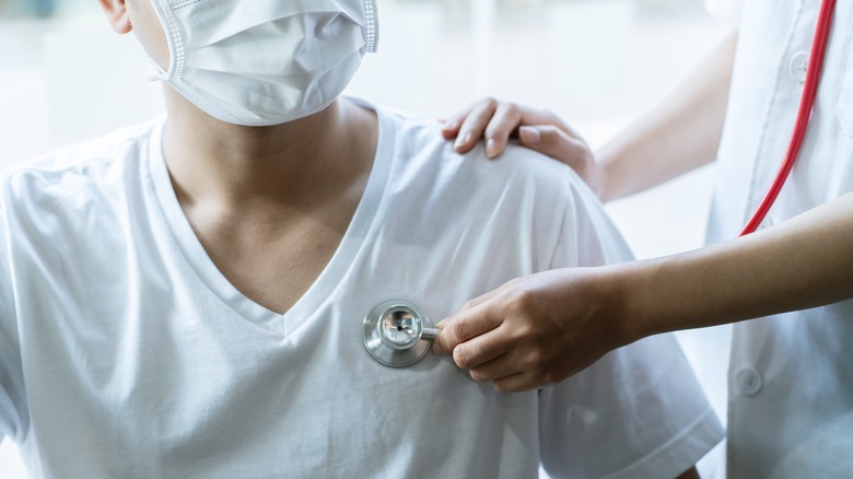 doctor using stethoscope on man
