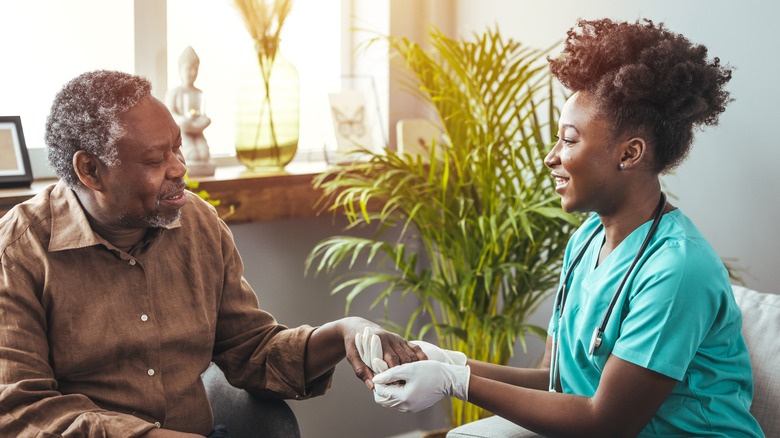 A nurse holds hands with a patient