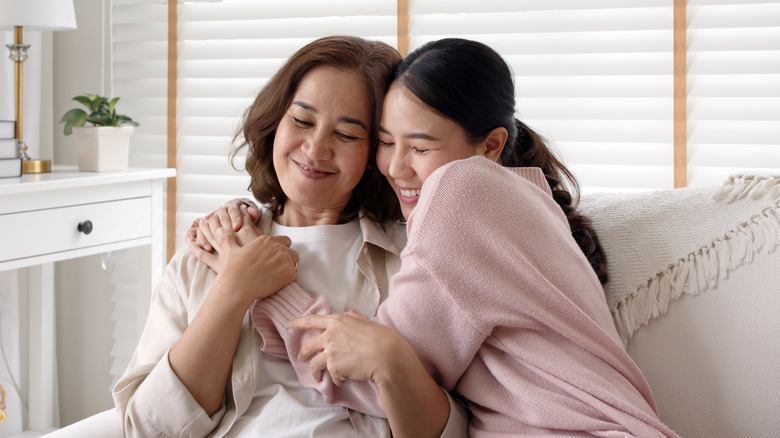 A woman and her daughter hug