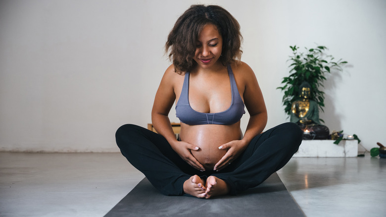 Young pregnant woman on yoga mat