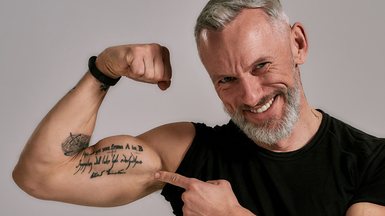 mature man pointing at bicep