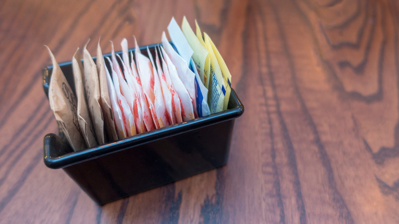 A tray of artificial sweetener packets on a table