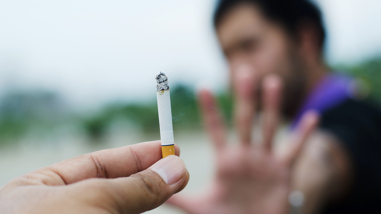 Hand stopping an offered cigarette