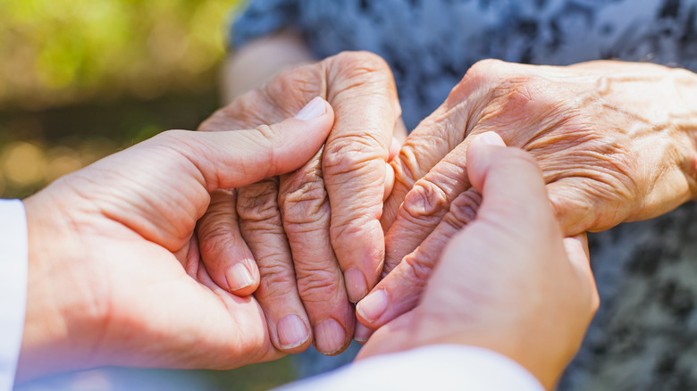 someone holding elderly person's hands