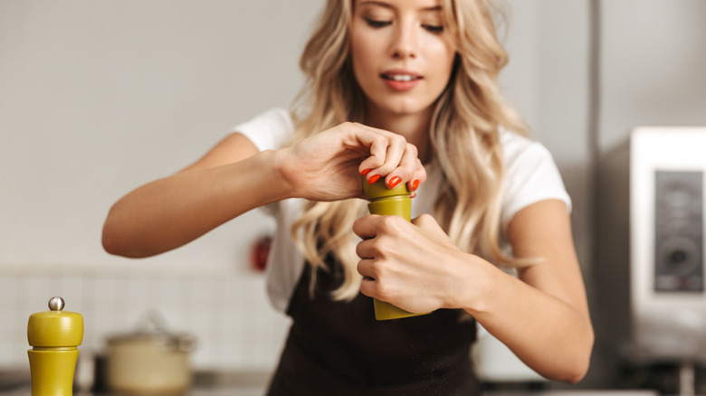 Woman add salt to her food