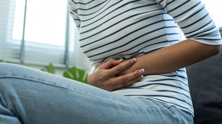 Woman clutching stomach in pain