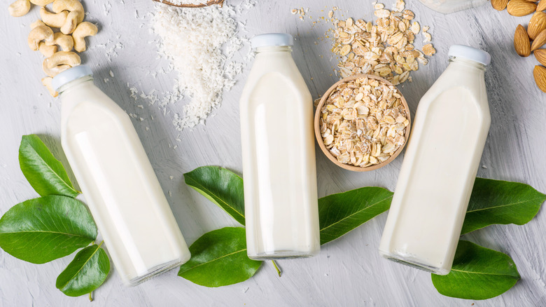 Three glass bottles containing different dairy replacement milks