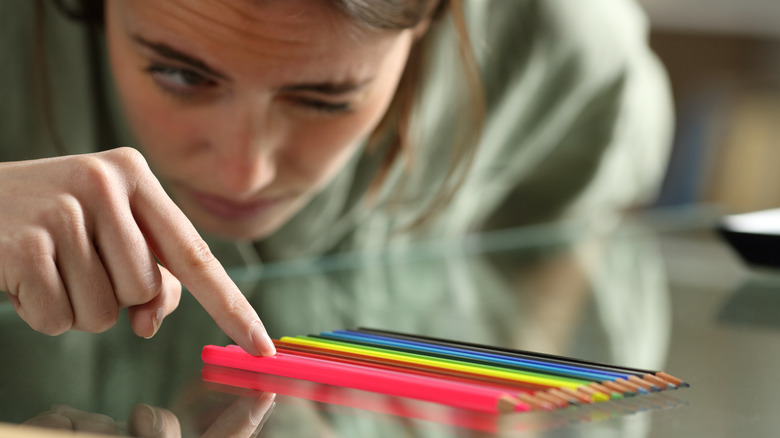 woman lining up colored pencils