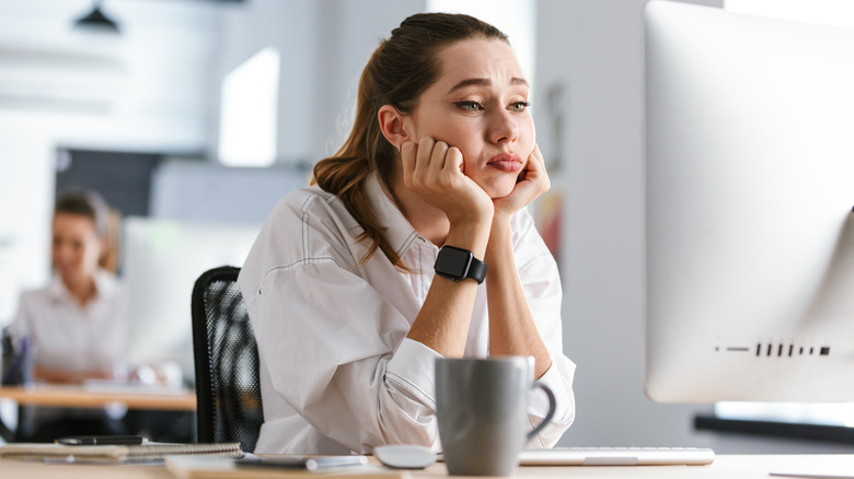 Bored woman at office job desk 