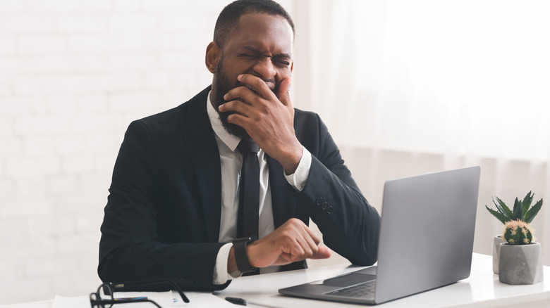Man yawning at work