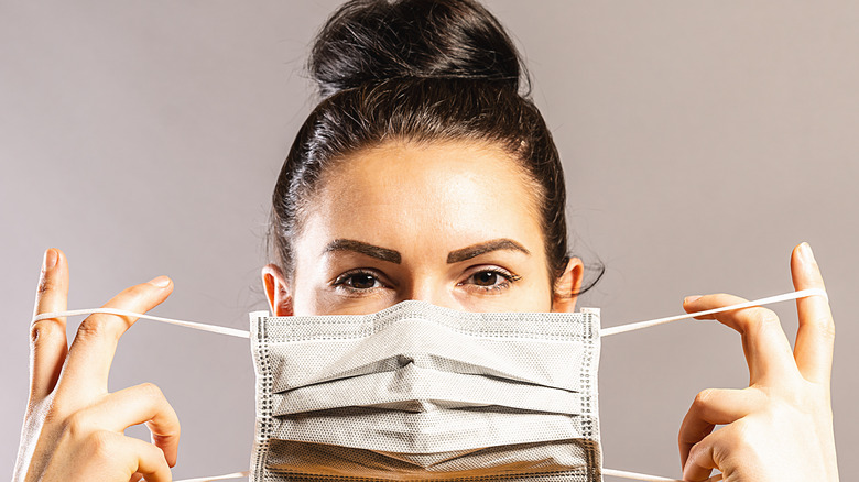 woman putting on face mask