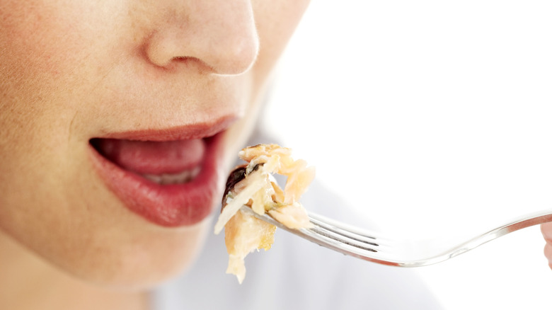 woman with a forkful of chicken breast