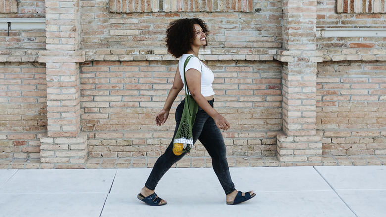 A woman walking on a city sidewalk