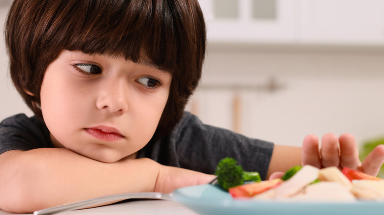 A little boy refusing to eat vegetables