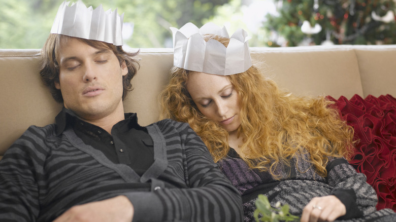 a couple asleep on the couch after a meal