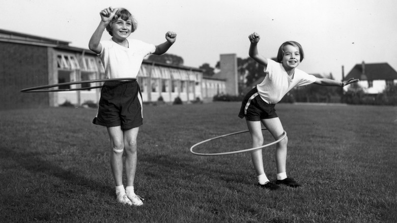 Two little girls playing with hula hoops
