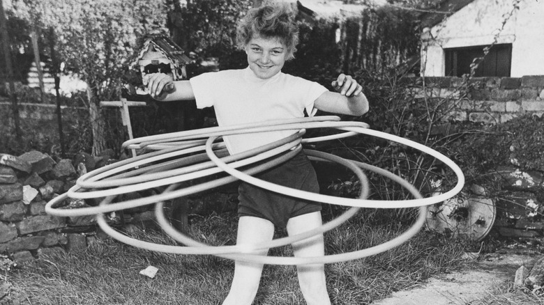 Little girl using seven hula hoops at once