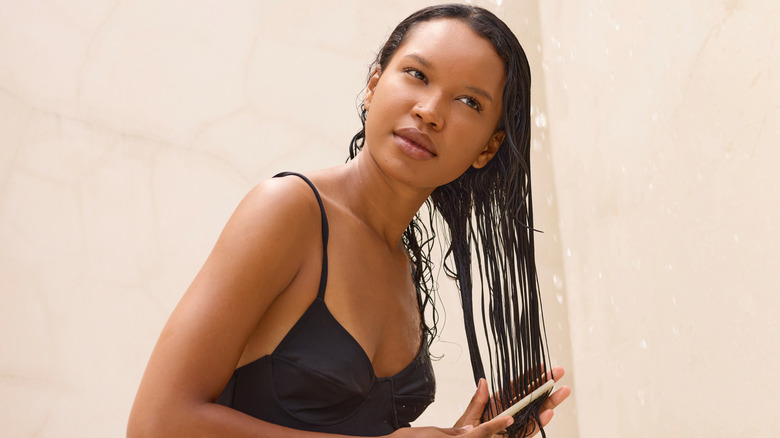 Woman combing her hair in the shower