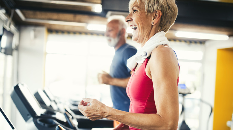 Senior man and woman running on a treadmill