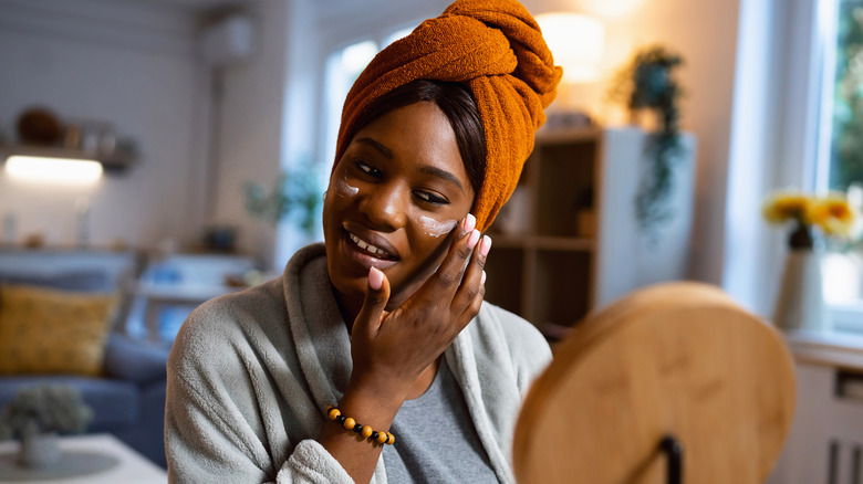 Woman applying moisturizer