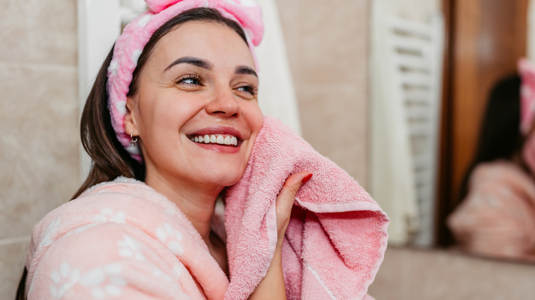 Woman patting her face with a towel