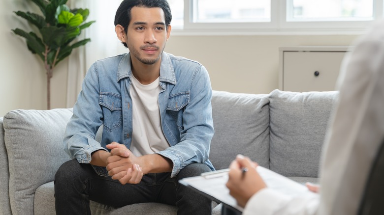 young man talking with a therapist or doctor in office