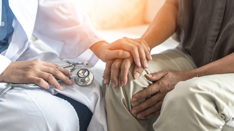 Doctor putting hand on patient