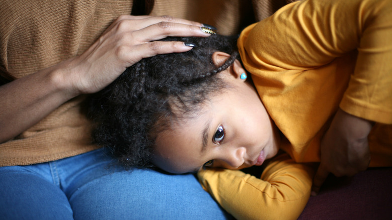 Sick child laying on parent's lap