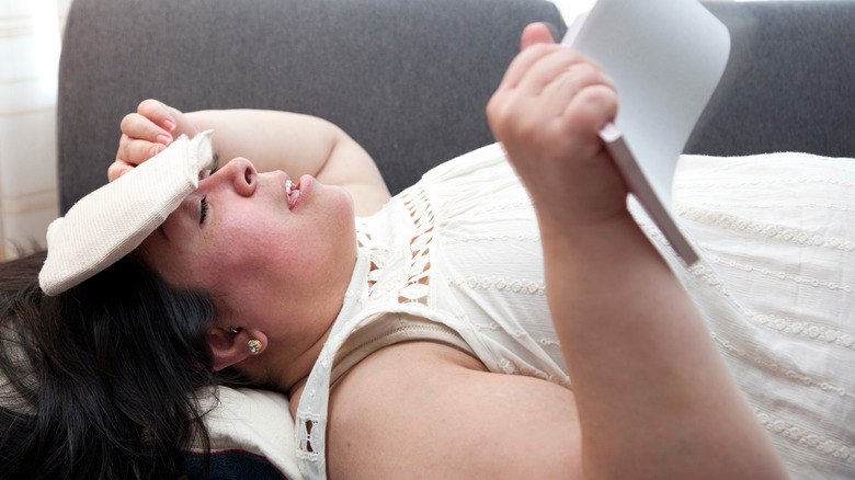 Anxious woman with ice pack on head