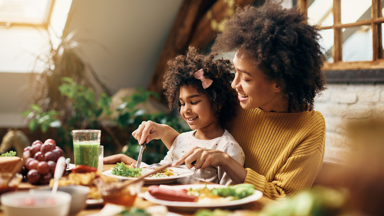 a mom and daughter eating breakfast together 