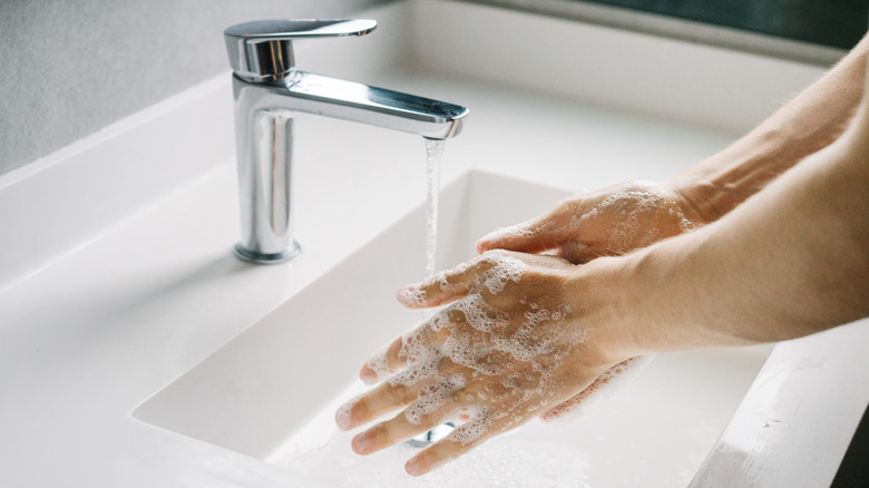 A man's hands washing in the sink