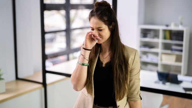 woman covering nose and wincing