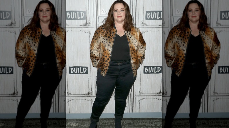 Melissa McCarthy smiling while wearing a leopard print coat