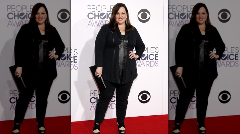 Melissa McCarthy smiling while wearing an all-black outfit
