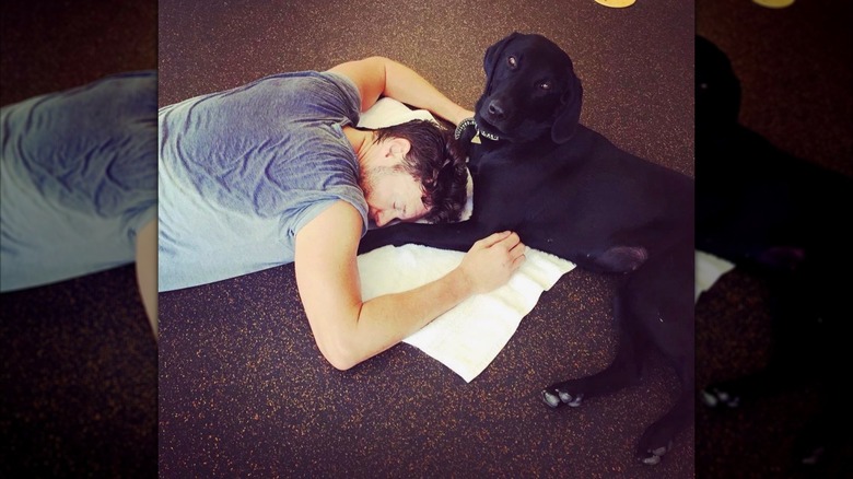 Ryan Seacrest laying on the floor after a sweaty workout with his dog Georgia