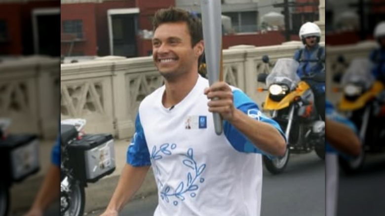Ryan Seacrest running with a torch for Team USA
