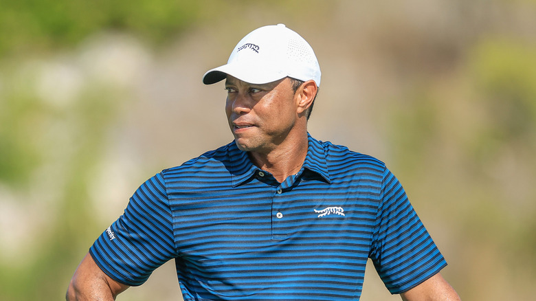 Tiger Woods posing with his golf club on a course