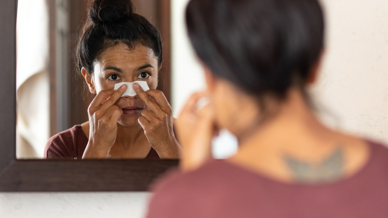 Woman removing blackheads