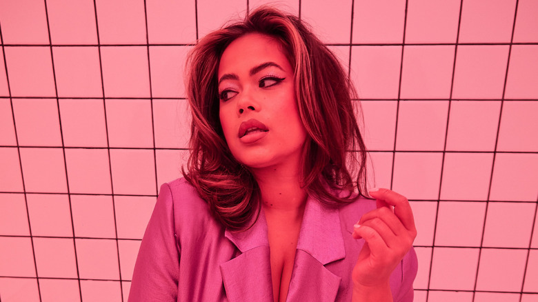Catie Li sitting on a bench in pink