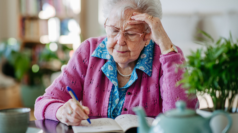 A senior woman doing crossword puzzles