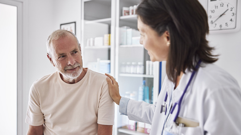 A senior man talking to his doctor in an exam room