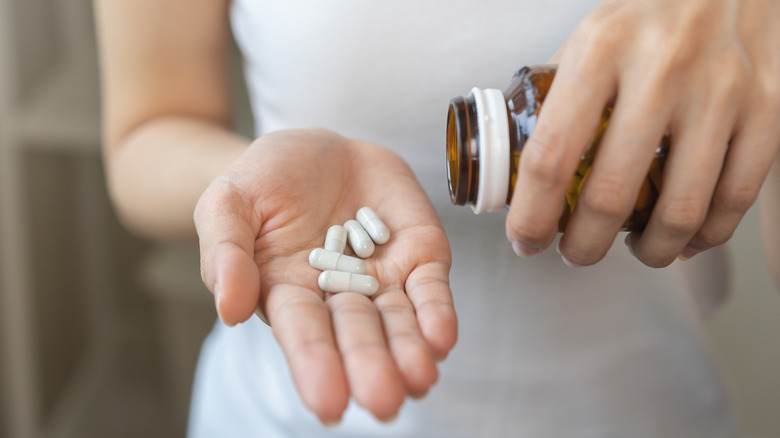 A woman's hand holding a few capsules