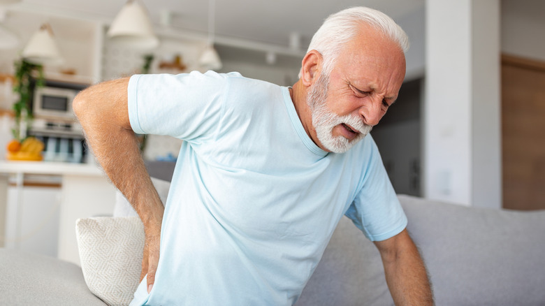 Man holding lower back in pain