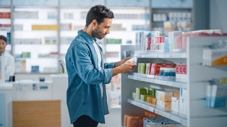 Man at drug store reading label