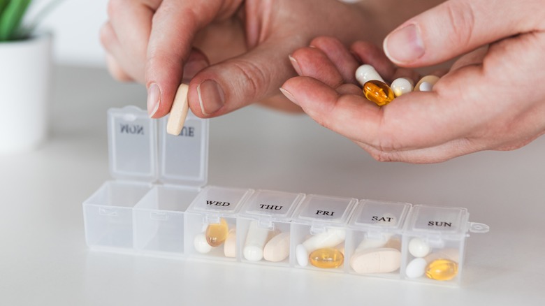 Person sorting pills in box