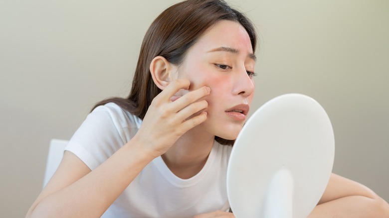 Woman looking concerned in mirror