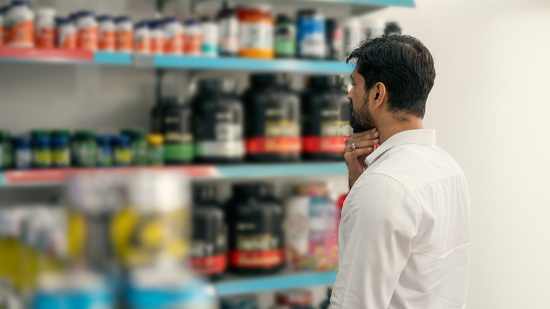 man considering shelf of powdered products