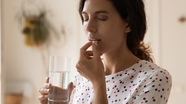 Sad-looking woman taking medication