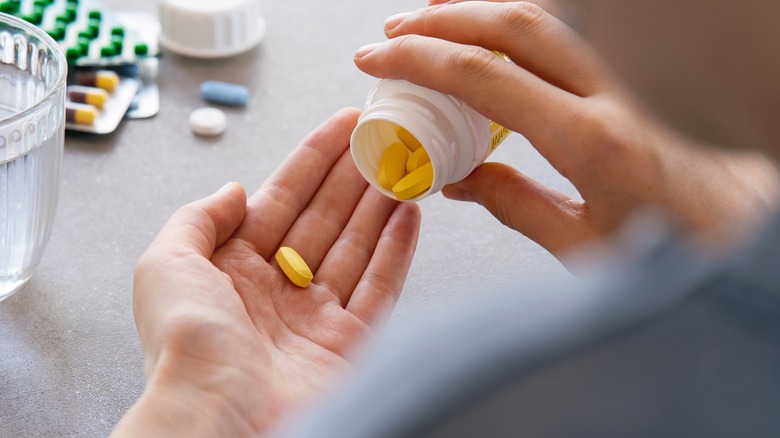 Woman taking pills from bottle